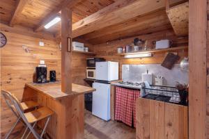 une cuisine dans une cabane en bois avec une cuisinière et un réfrigérateur dans l'établissement Petite maison de bois, à Banyuls-dels-Aspres
