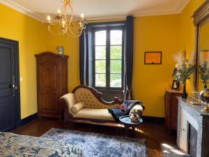 a living room with a couch and a dog laying on a table at La Maison de Maître Chagnon Aumagne in Aumagne