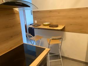 a kitchen with a counter with two chairs and a stove at Les Brises in Saint-Gingolph