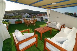 a balcony with chairs and a table on a roof at Teraslı Müstakil Ev in Cunda
