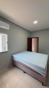 un dormitorio con una cama grande en una habitación en Casa 3 Quartos , Ar Condicionado e Área de Churrasco com Ducha, en Juazeiro