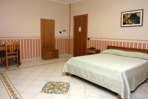 a bedroom with a bed and a table and a chair at Hotel La Vecchia Quercia in Cerreto Sannita