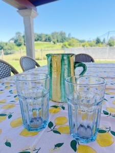 a table with two glasses and two vases on it at Casa María B - a 3km del Camino in Santa Eulalia +17 photos