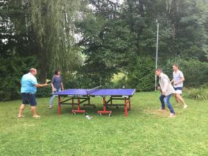 a group of people playing ping pong on a picnic table at 2 hálószobás vendégház in Balatonboglár