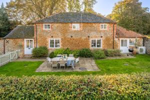 a brick house with a table and chairs in the yard at The Coach House R 6 in Ringstead