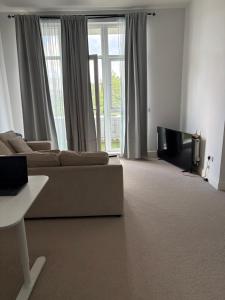 a living room with a couch and a tv at Borehamwood Apartment in Borehamwood