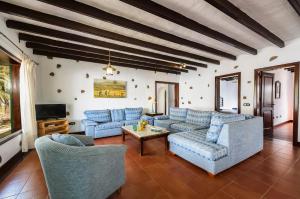 a living room with blue couches and a tv at Finca La Crucita - Maguez in Haría