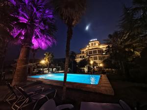 a hotel with a swimming pool at night at Hotel Palma in Gjirokastër