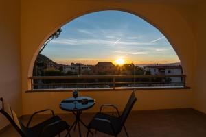 a balcony with an arched window with a table and chairs at Floral Apartment in Castellammare di Stabia