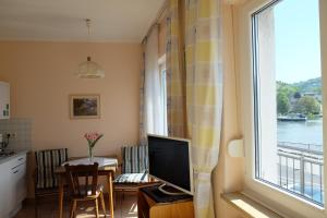 a living room with a television and a window at Panorama-Café MOSELGARTEN in Alf