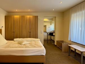 a bedroom with a large bed and a kitchen at Engelhard Das Landhotel Garni in Kirchheim am Ries +61 photos