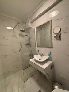 a bathroom with a sink and a glass shower at Leonidas Apartments & Suites 2 in Mola Kalyva +28 photos