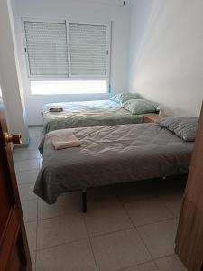 Postel nebo postele na pokoji v ubytování CASA COMPARTIDA SIn ASCENSOR ELDA