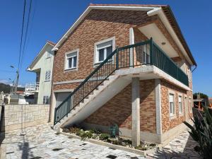 a brick house with a staircase on the side of it at Casa Outeiro Polo 2 in Marinhas