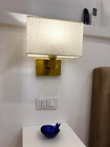 a lamp on a table with a blue bowl on it at Syrene Suites Sorrento in Piano di Sorrento