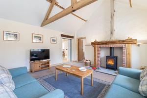 a living room with a blue couch and a fireplace at Grange Cottage in York