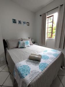 um quarto com uma cama com um cobertor azul e branco em CASA a 550 METROS DA SAÍDA DOS PASSEIOS DE BARCO NA PRAIA DOS ANJOS 1 VAGA DE GARAGEM em Arraial do Cabo