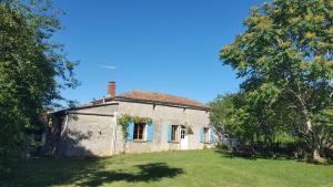 una vieja casa de piedra en un campo con árboles en Gîte Chez Chenon, en Saint-Sulpice-de-Ruffec