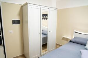 a bedroom with a closet with a bed and a mirror at Stanza Aragona in Santa Maria a Vico