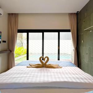 ein Bett mit zwei hölzernen Herzen darauf in der Unterkunft Luxury Villa pemandangan sawah - fulton Regatta 3BR in Ngaglik