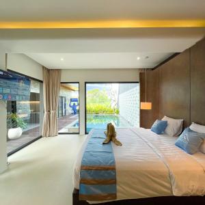 a bedroom with a large bed with a teddy bear sitting on it at Luxury Villa pemandangan sawah - fulton Regatta 3BR in Ngaglik