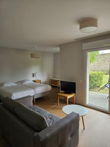a living room with a couch and a bed and a bedroom at Domitys Le Griffon d’Or in Saint-Brieuc