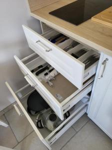 a kitchen cabinet with a drawer filled with appliances at L'Impasse du Jura in Ménétru-le-Vignoble +22 photos