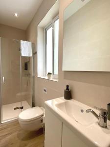 a white bathroom with a toilet and a sink at Tan-Nanniet Apartment in Marsaxlokk +8 photos