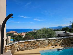 a view of the ocean from the balcony of a house at Magnifique villa avec piscine- hauteurs de Bastia in Bastia