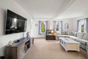 a living room with a couch and a flat screen tv at Walk to Water Access to Hiking Trails! in Harwich
