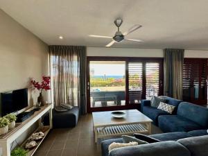 a living room with a blue couch and a table at Boca Gentil Sunrise 9 in Jan Thiel