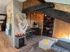 a living room with a fireplace and a bar at Un soupçon de magie - 2min Gare - Direct Genève in Bellegarde-sur-Valserine +18 photos