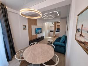 a living room with a table and a blue couch at Sunrise Breeze Apartment in Constanţa