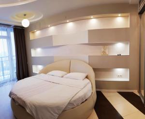 a bedroom with a large bed with white sheets at Семейные апартаменты в Мост Сити зал и 1 спальня, вид на реку, балкон Ванна in Dnipro