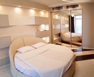 a bedroom with a white bed and a mirror at Семейные апартаменты в Мост Сити зал и 1 спальня, вид на реку, балкон Ванна in Dnipro