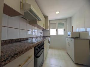 a kitchen with a sink and a stove at Atico Piles in Piles