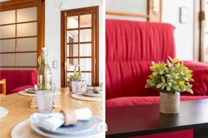 a living room with red furniture and a table with a vase of flowers at Mediterranean Way - Anguera in Cambrils