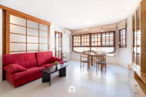 a living room with a red couch and a table at Mediterranean Way - Anguera in Cambrils