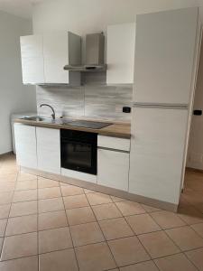 a kitchen with white cabinets and a stove at La Maison di Vicolo Torre in Uboldo