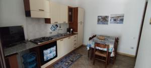 a small kitchen with a stove and a table at Sa Domu De Pardinu in Cardedu +38 photos
