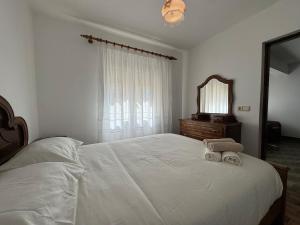 a bedroom with a large white bed and a mirror at Casa Outeiro Polo 1 in Marinhas