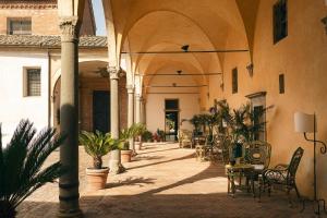 an empty courtyard with chairs and tables in a building at Hotel Certosa Di Maggiano in Siena +91 photos