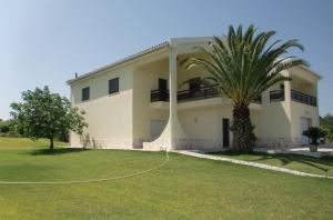 una casa con una palmera delante de ella en Quinta da Harmonia, en Azeitão