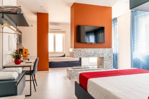 a bedroom with two beds and a tv on the wall at Floral Apartment in Castellammare di Stabia