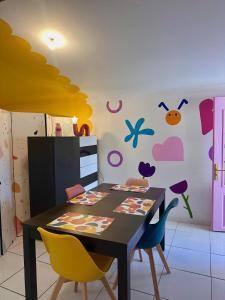 a dining room with a table and chairs at POP HOUSE - Appartement coloré et fun en Camargue in Saint-Gilles