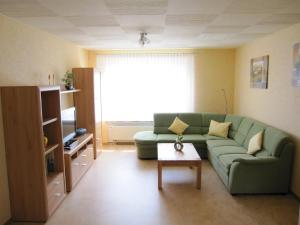 sala de estar con sofá verde y mesa en Ferienwohnung Schönhense, en Medebach