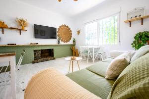 Una sala de estar con un sofá y una chimenea. en Blue Castle GuestHouse, en Málaga