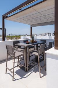 eine Terrasse mit einem Tisch und Stühlen auf dem Dach in der Unterkunft Modern Villa in Santa Rosalía with Rooftop View BY COELI HOME LIVING in Torre-Pacheco