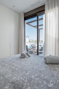 ein Schlafzimmer mit einem Bett mit zwei Handtüchern darauf in der Unterkunft Modern Villa in Santa Rosalía with Rooftop View BY COELI HOME LIVING in Torre-Pacheco