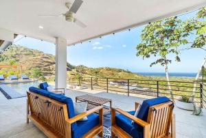 a patio with two blue chairs and a table at Ocean View Villa & Private Pool in Mar Vista in Brasilito